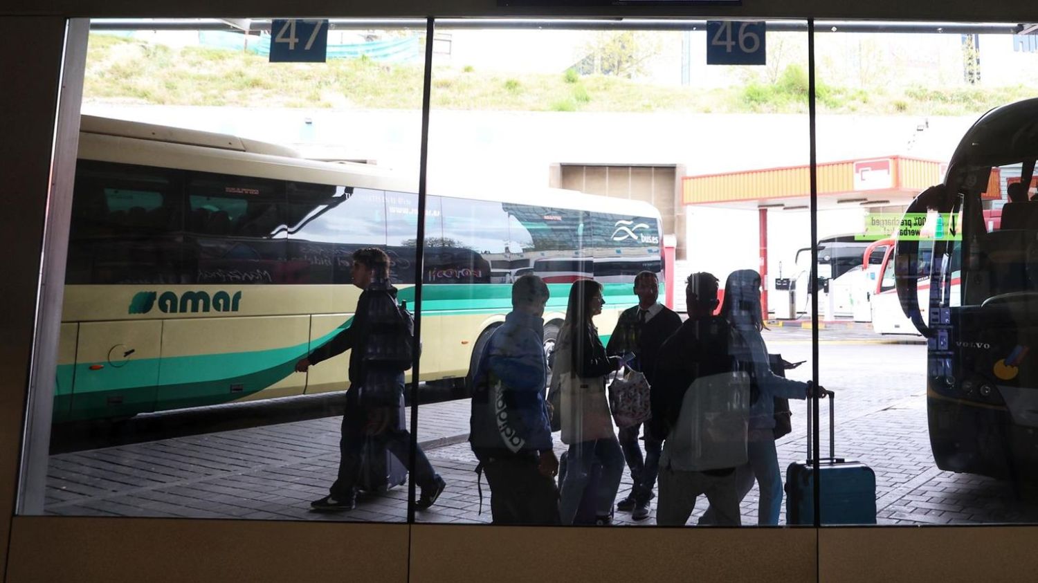 Un grupo de personas frente a un autocar.